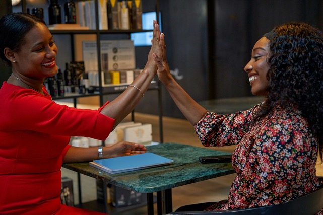 Women high-fiving: Wellness Coaching